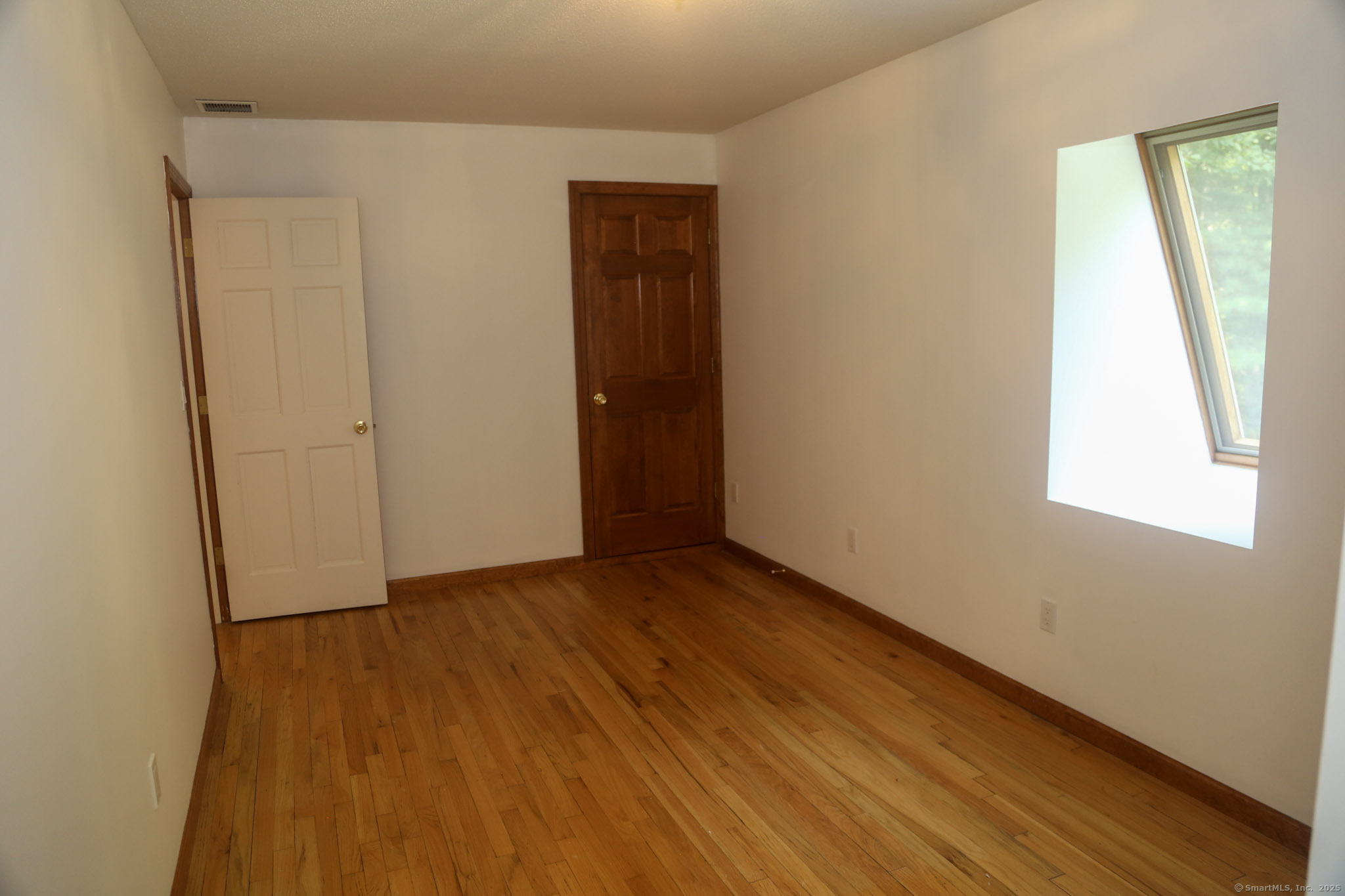 189 Crane Hollow Road Bethlehem, CT 06751 - Photo 14 of 40 an empty room with wooden floor and windows