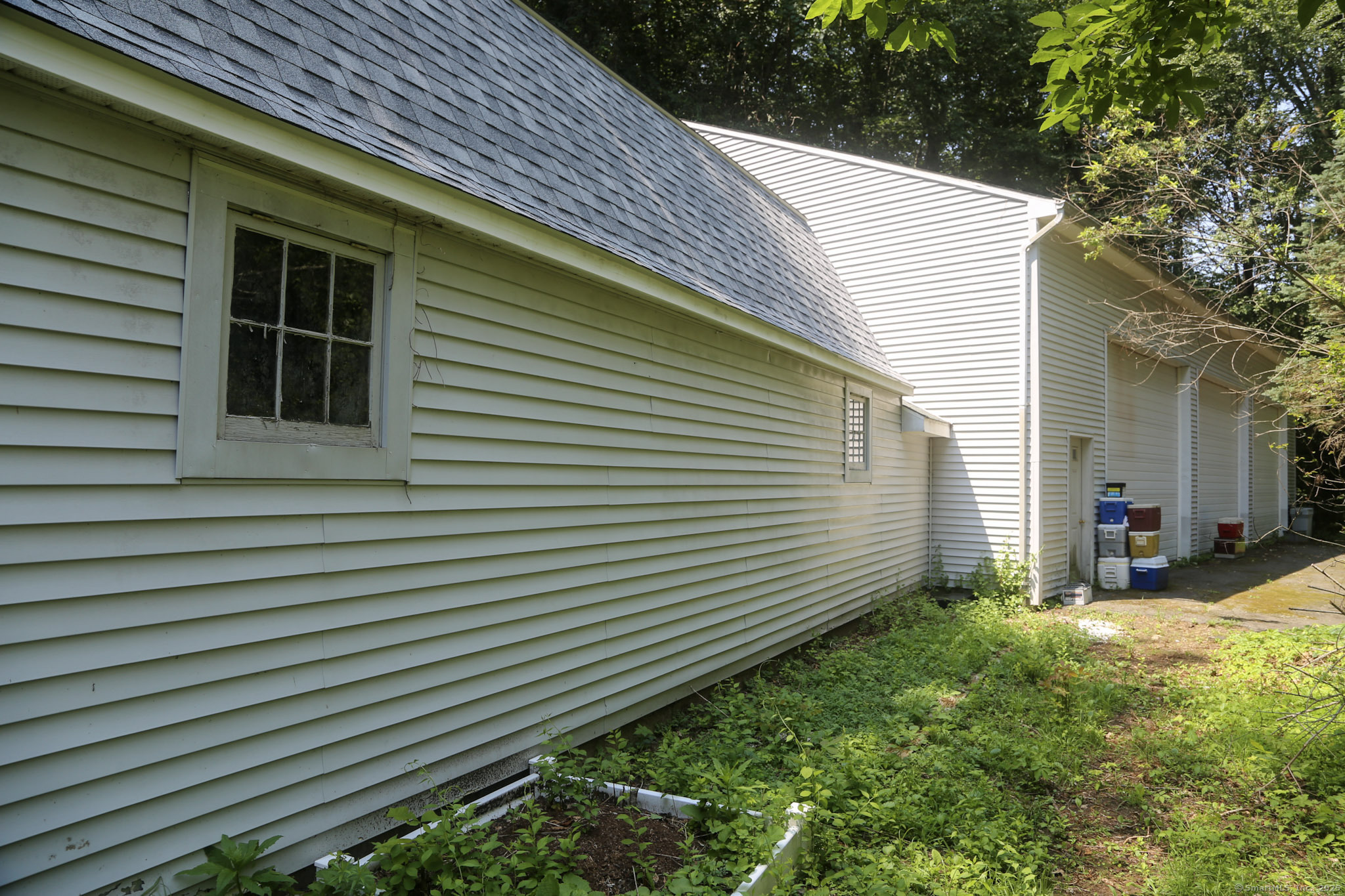189 Crane Hollow Road Bethlehem, CT 06751 - Photo 26 of 40 a view of a backyard with plants and a large tree