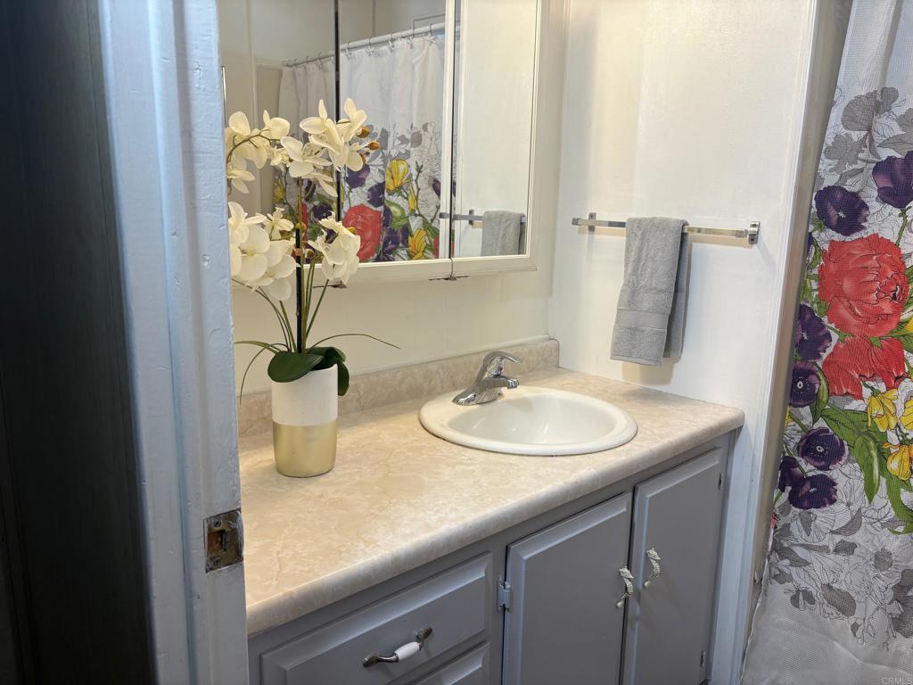 1174 East Main Street, Unit 113 El Cajon, CA 92021 - Photo 16 of 25 a bathroom with a sink a vanity and a mirror