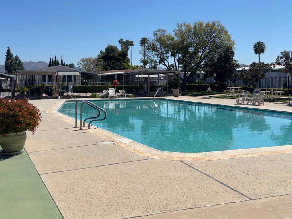 1174 East Main Street, Unit 113 El Cajon, CA 92021 - Photo 25 of 25 a view of a swimming pool with a table and chairs under an umbrella