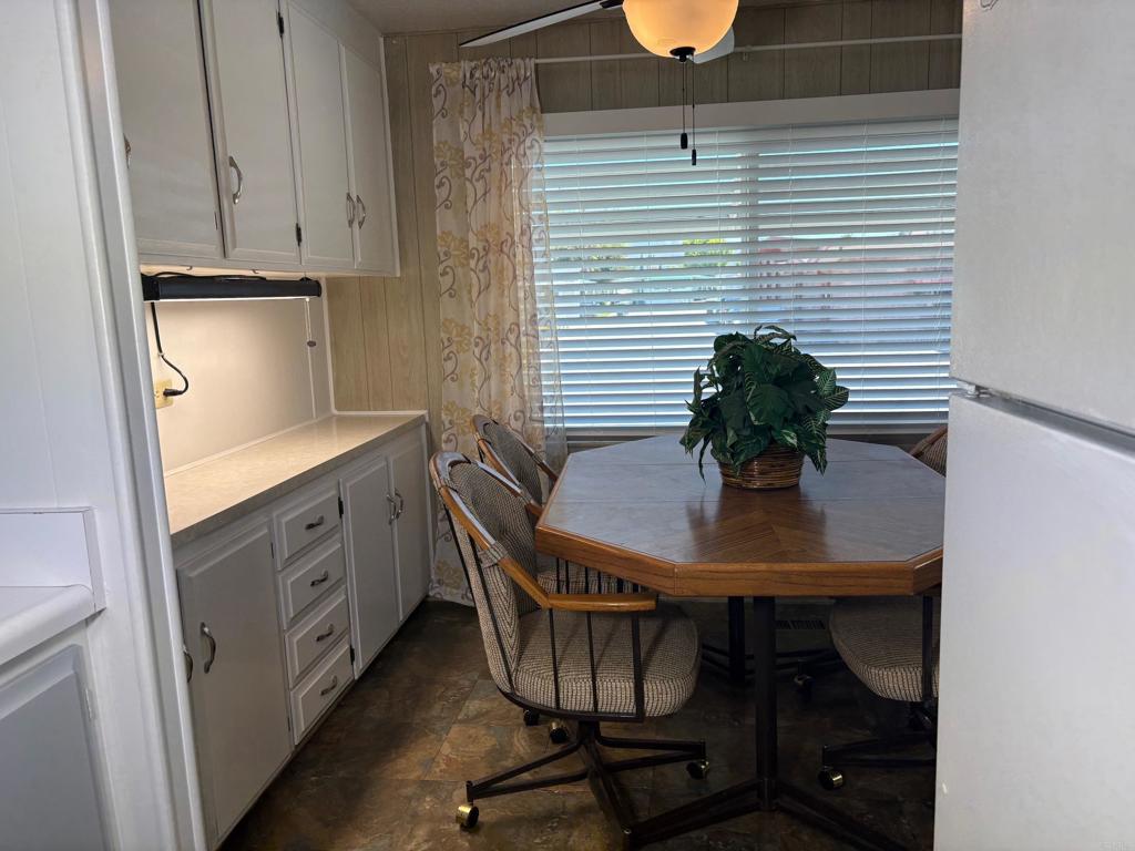 1174 East Main Street, Unit 113 El Cajon, CA 92021 - Photo 7 of 25 a kitchen with a table chairs and cabinets