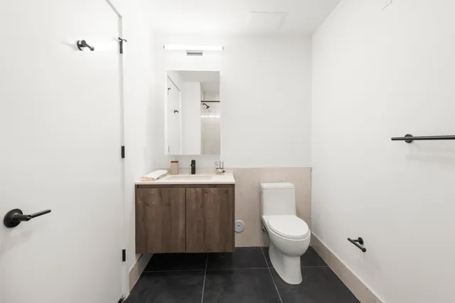 a bathroom with a toilet a sink and mirror