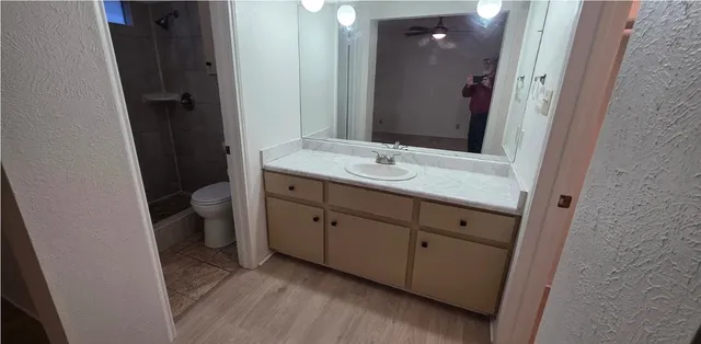 a bathroom with a granite countertop sink toilet and mirror