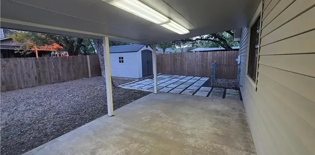 a view of a house with a yard and large tree