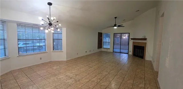 a view of a room with a ceiling fan window and wooden floor