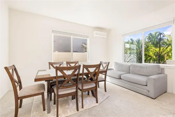 a view of a dining room with furniture and a potted plant