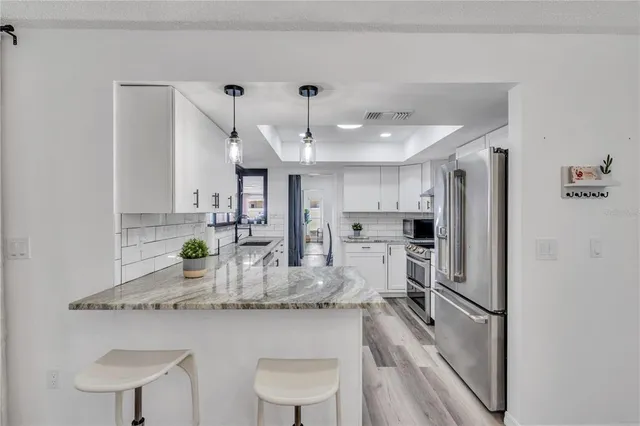a kitchen with refrigerator and chairs
