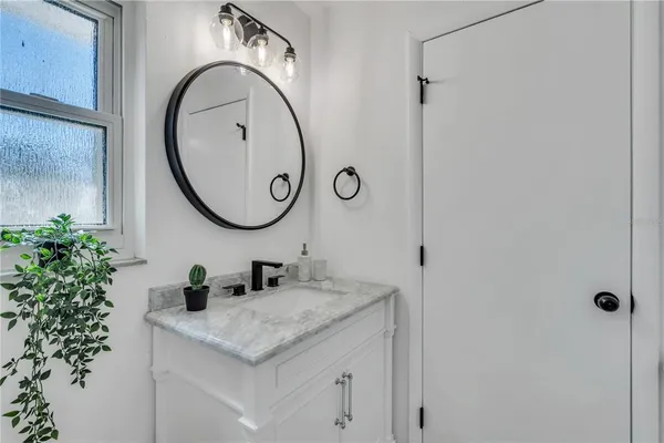 a bathroom with a granite countertop sink and a mirror