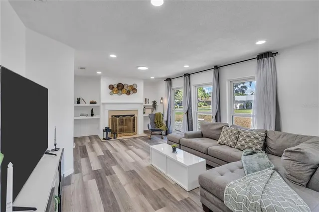 a living room with furniture large window and a fireplace