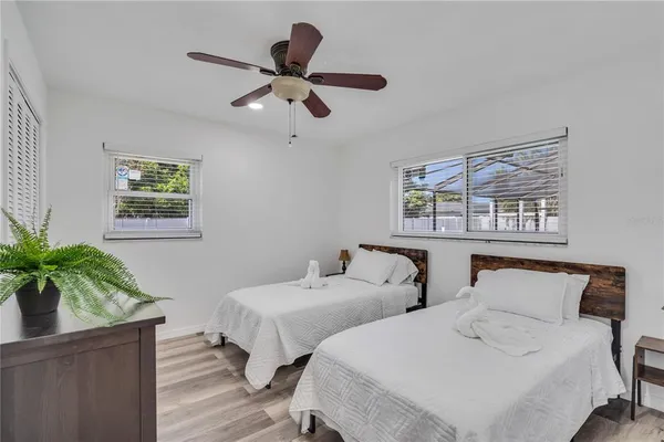 a bedroom with two beds and a potted plant