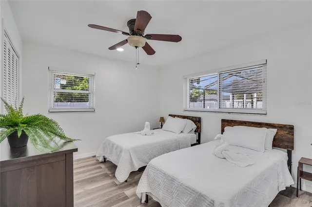 a bedroom with two beds and a potted plant