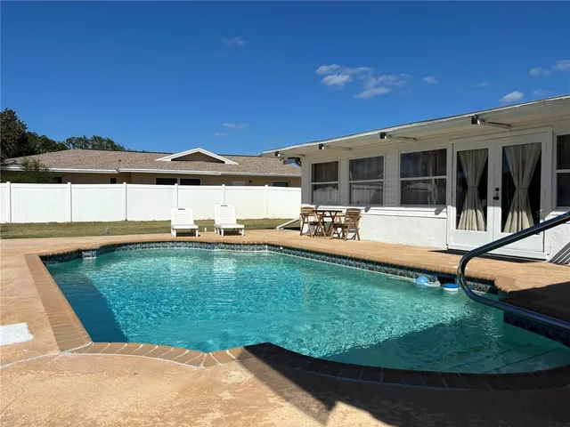 a view of a house with swimming pool and sitting area