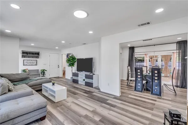 a living room with furniture and a wooden floor