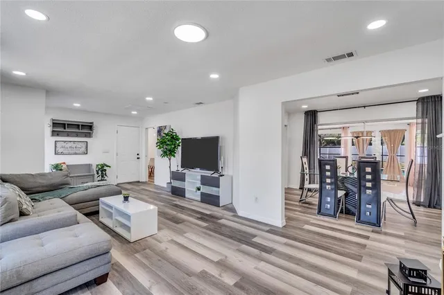 a living room with furniture and a wooden floor