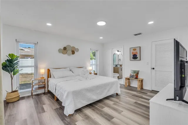 a bedroom with a bed and a flat screen tv