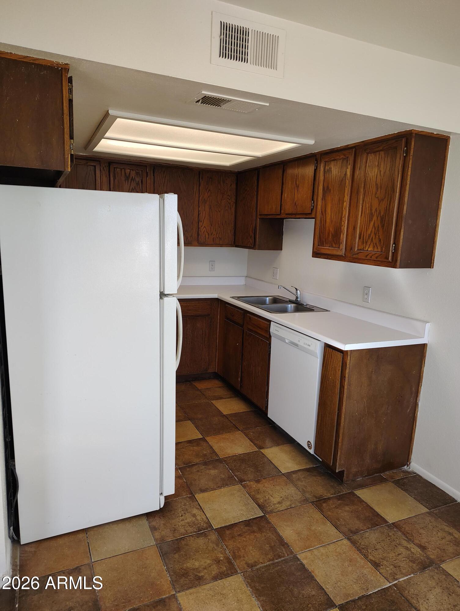 2560 South Yavapai Road Apache Junction, AZ 85119 - Photo 13 of 31 a kitchen with stainless steel appliances granite countertop a sink and a refrigerator