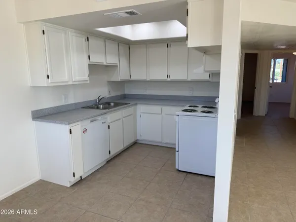 a kitchen with granite countertop a sink a stove and cabinets