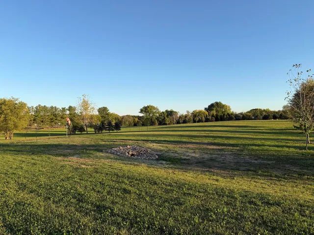 a view of a field of grass and covered with wooden fence
