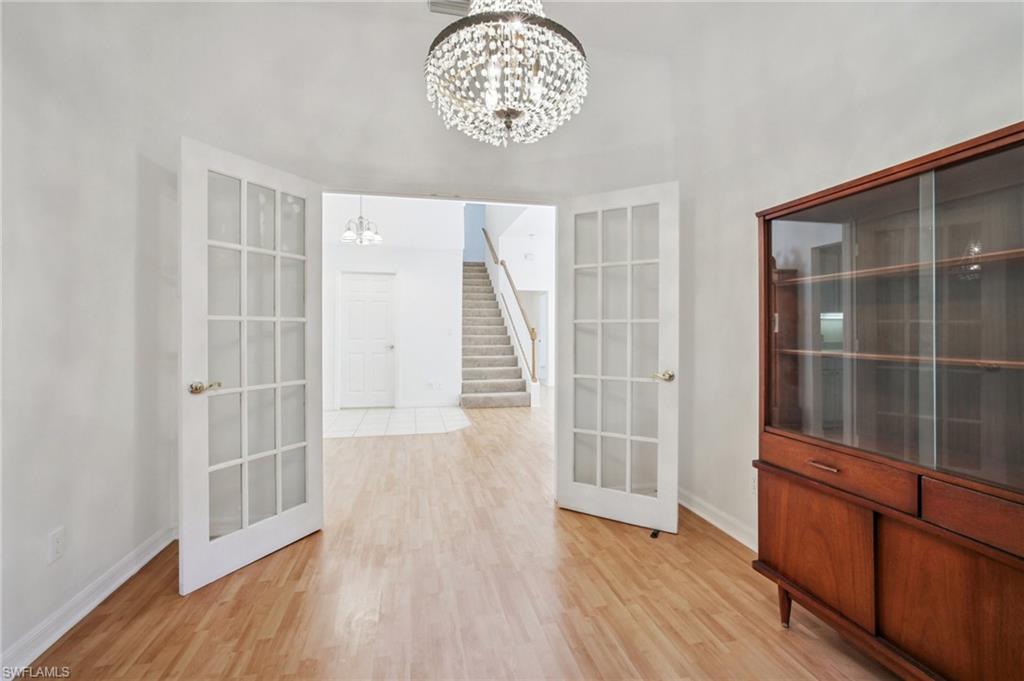5348 Cypress Lane Naples, FL 34113 - Photo 19 of 28 wooden floor in an empty room with a window