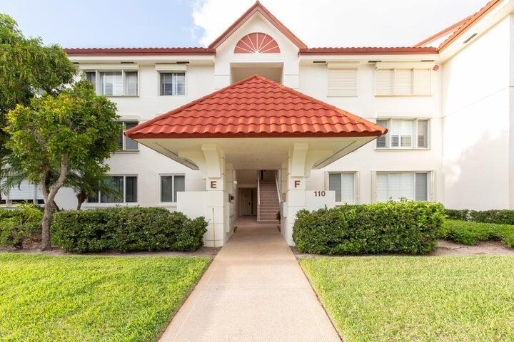 110 Half Moon Circle, Unit E2 Hypoluxo, FL 33462 - Photo 9 of 14 a front view of a house with a yard and garage