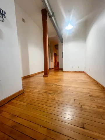 a view of an empty room with wooden floor