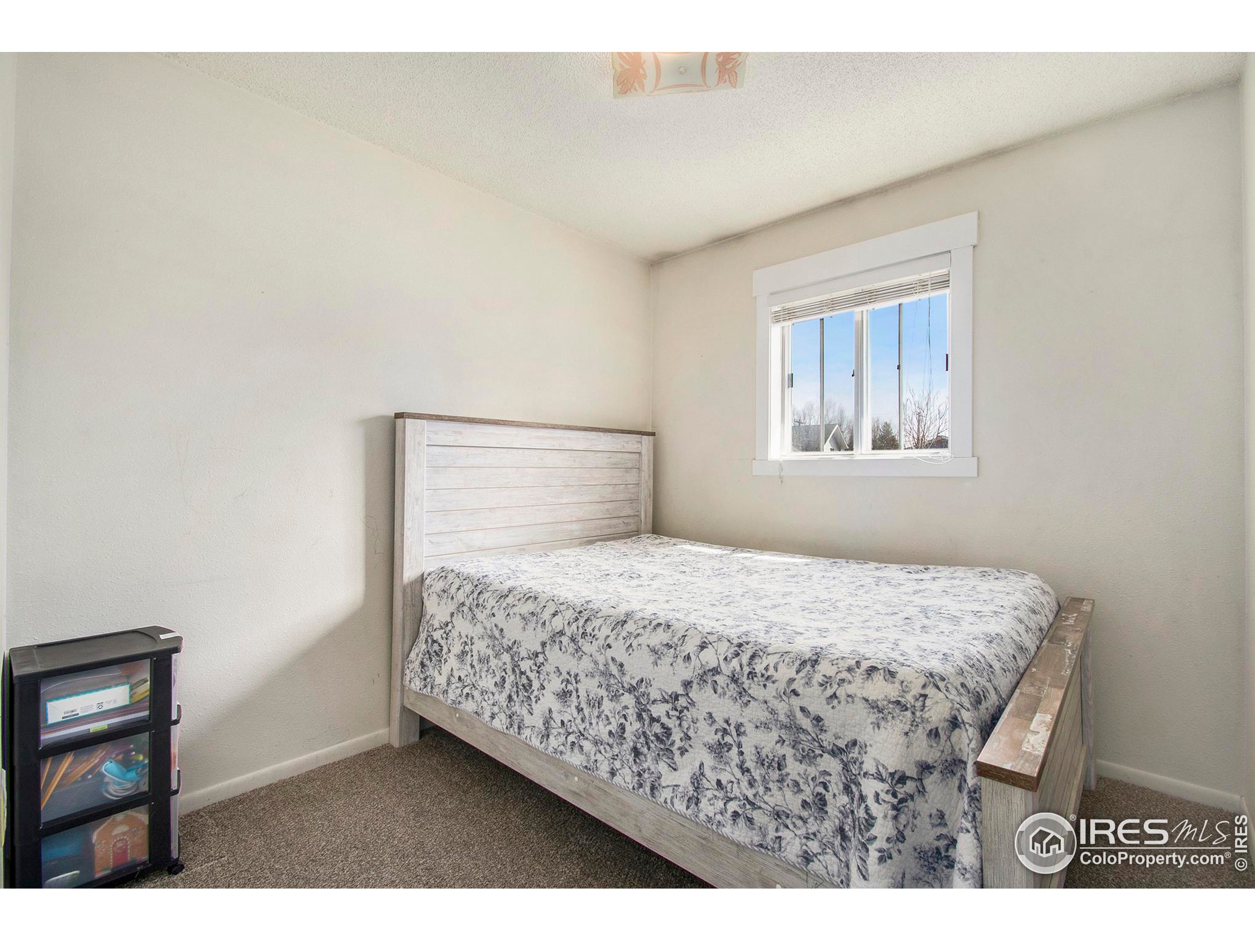 3231 West 5th St Road Greeley, CO 80634 - Photo 13 of 31 a bedroom with a bed window and a table