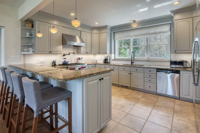 a kitchen with a sink a stove a table and chairs in it