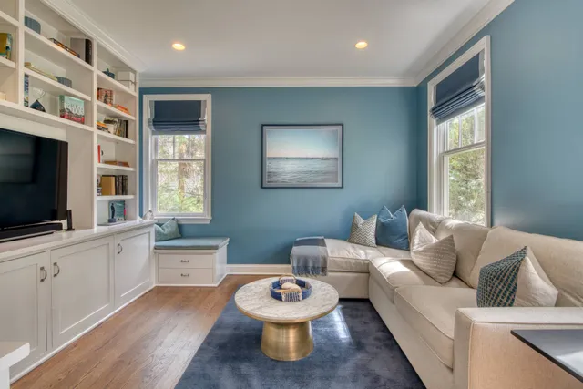 a living room with furniture a flat screen tv and a window