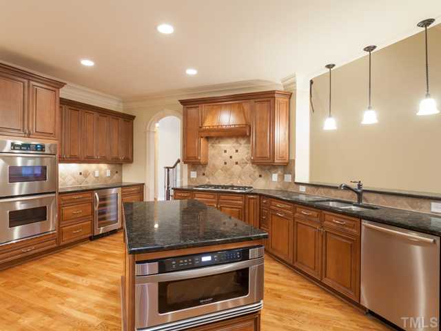 12816 River Dance Drive Raleigh, NC 27613 - Photo 11 of 25 Kitchen appliances include a Sharp under-cabinet drawer-style microwave that opens with a push of a button, a Bosch dishwasher, KitchenAid Double Ovens, KitchenAid gas cooktop and beverage refrigerator.
