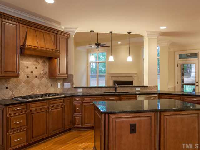 12816 River Dance Drive Raleigh, NC 27613 - Photo 12 of 25 Additional kitchen features include 3 pendant lights over the bar, a convenient work island, granite counter tops, custom cabinets, stainless cabinet pulls, and a pantry.