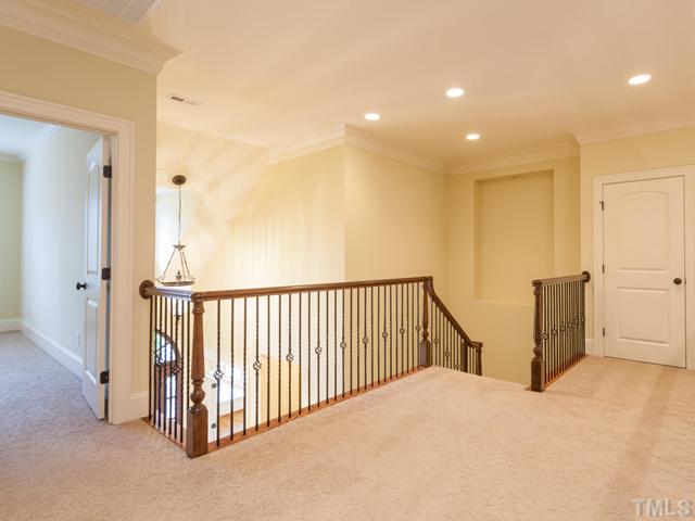 12816 River Dance Drive Raleigh, NC 27613 - Photo 19 of 25 The staircase and the second floor landing feature wrought iron railings. The door in the back right of this photograph is the door to the walk-in attic.
