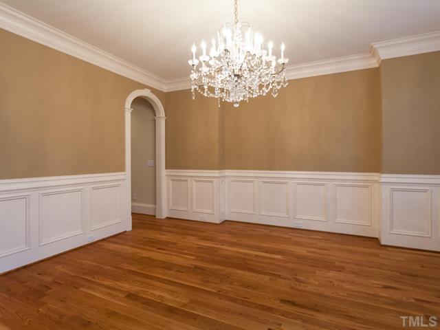12816 River Dance Drive Raleigh, NC 27613 - Photo 5 of 25 The elegant dining room offers beautiful wainscoting, chair railing, and deep crown molding. The arched doorway leads to the kitchen. The chandelier does not convey.