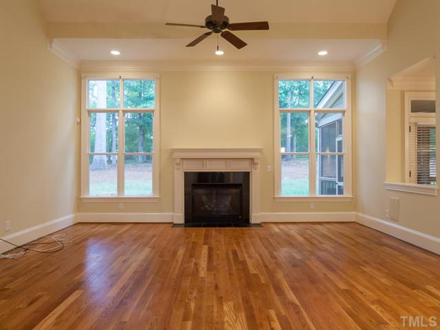 12816 River Dance Drive Raleigh, NC 27613 - Photo 8 of 25 Notice the view of the wooded backyard through the floor to ceiling windows. Additional features of the family room include a ceiling fan, gas fireplace, and recessed lighting.