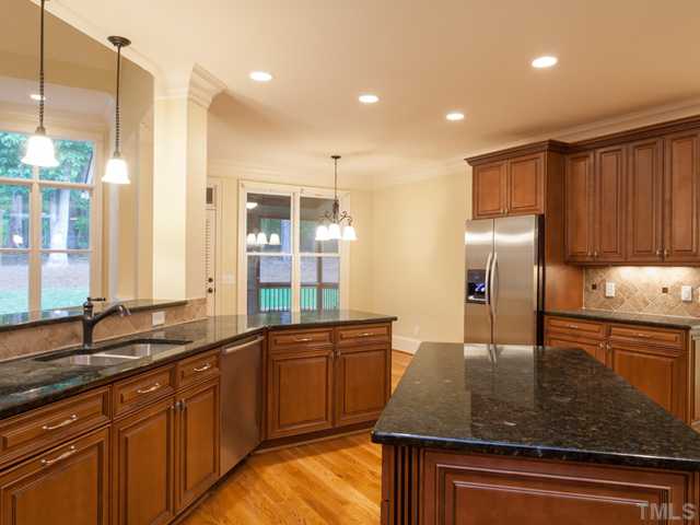 12816 River Dance Drive Raleigh, NC 27613 - Photo 10 of 25 The expansive kitchen offers stainless appliances, granite counter tops, tile back splash, under cabinet lighting and recessed lighting.