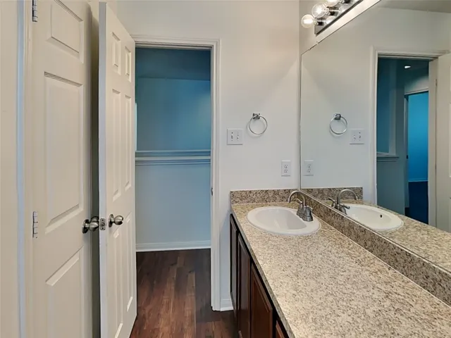a bathroom with a granite countertop sink a mirror and shower