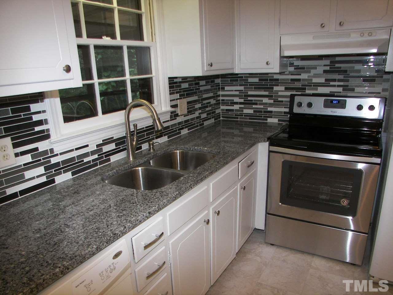 6729 Johnsdale Road Raleigh, NC 27615 - Photo 5 of 25 a kitchen with granite countertop a sink and a stove
