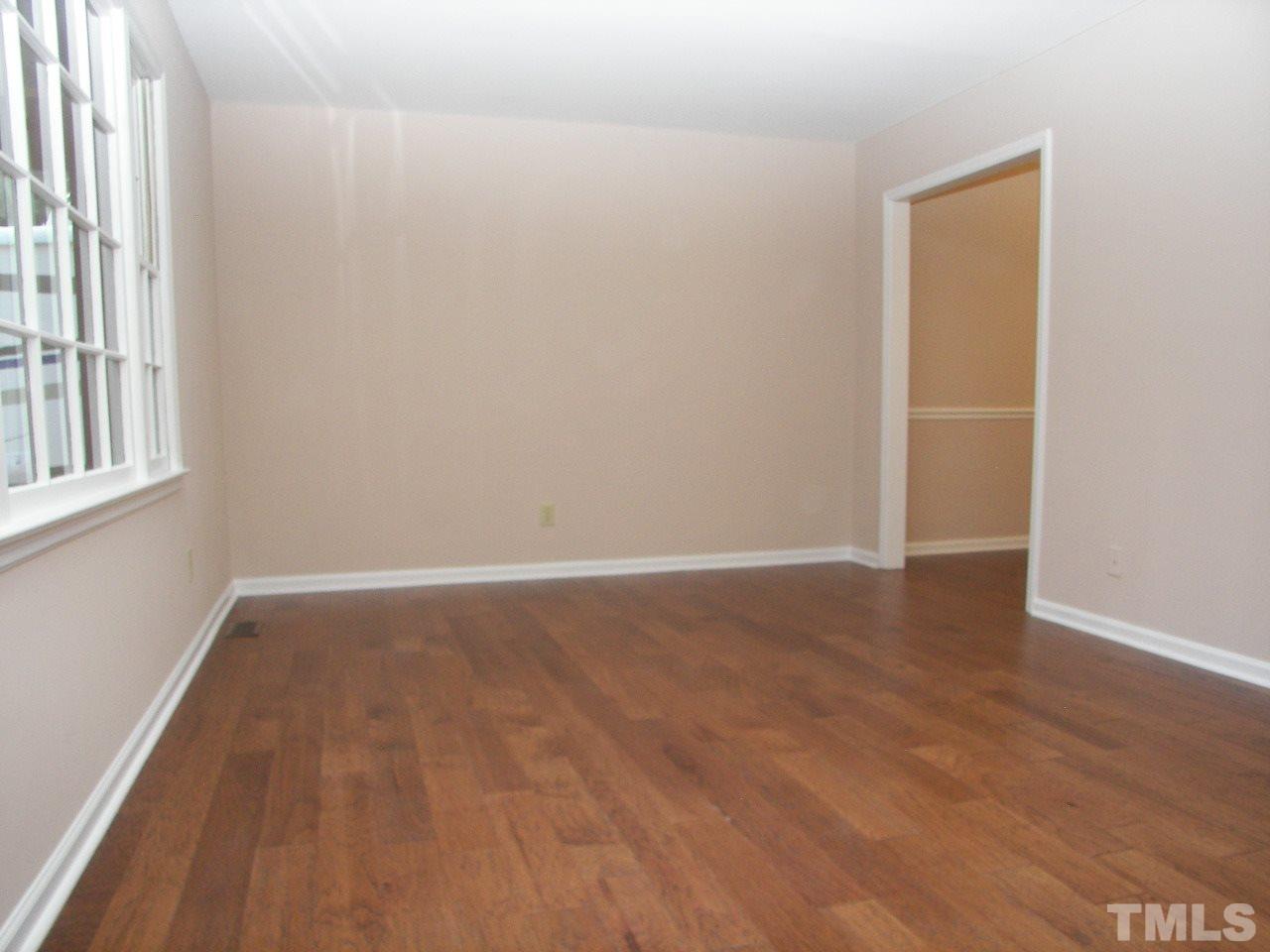 6729 Johnsdale Road Raleigh, NC 27615 - Photo 10 of 25 an empty room with wooden floor and windows