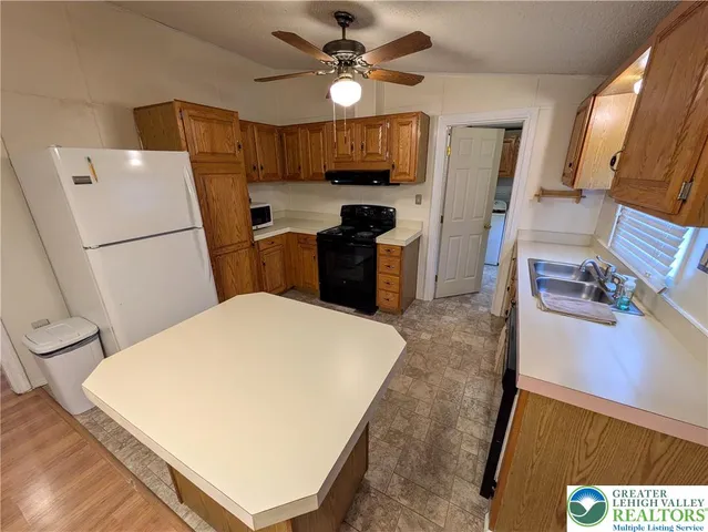 a kitchen with a refrigerator a stove top oven a sink and dishwasher