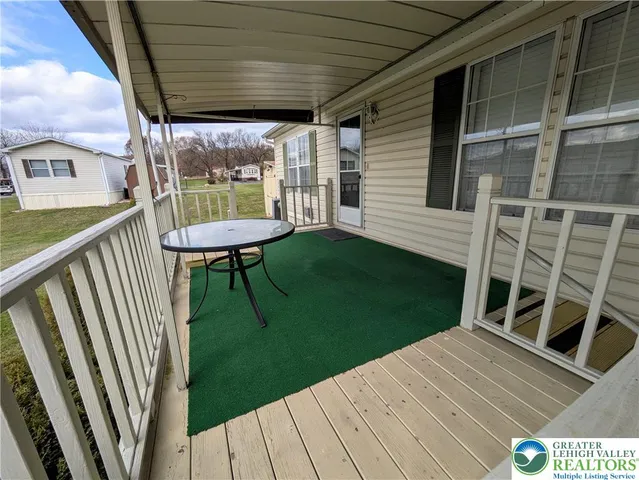 a view of a deck with a table and chairs with wooden floor and fence