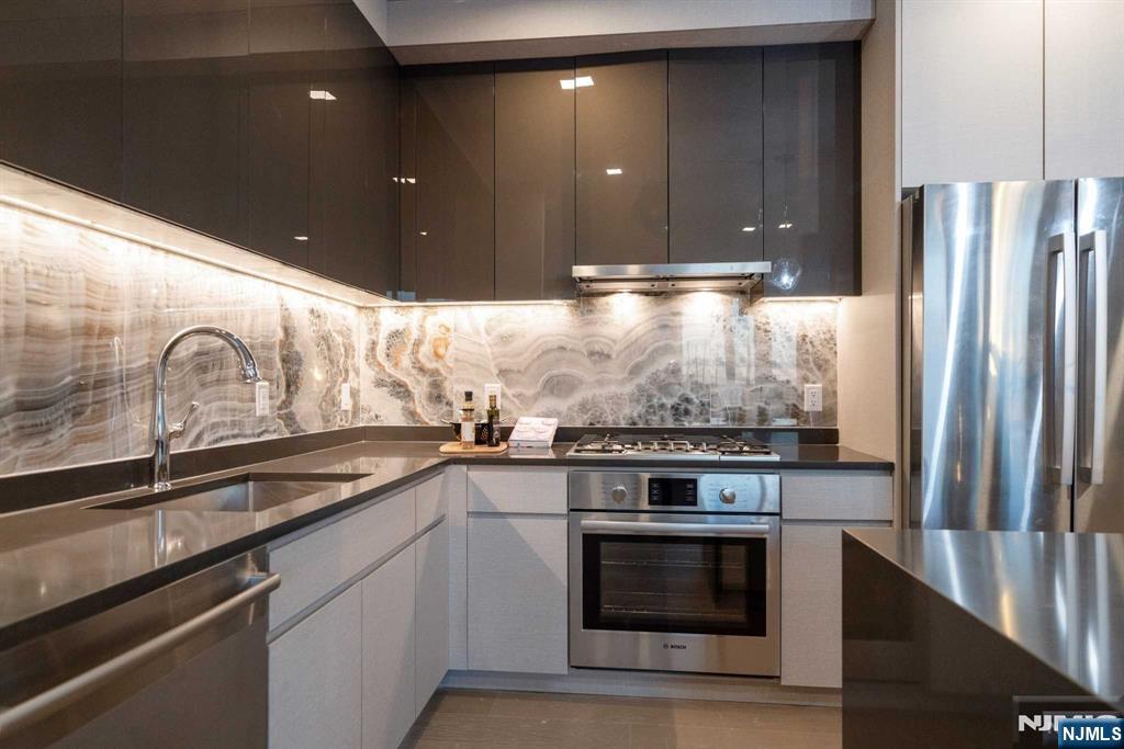 7101 River Road, Unit 304A North Bergen, NJ 07047 - Photo 3 of 24 a kitchen with stainless steel appliances granite countertop a stove and a refrigerator