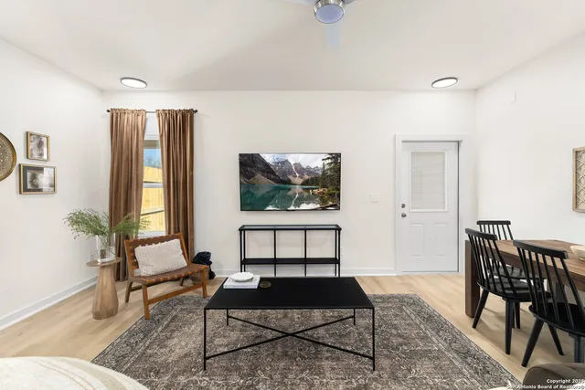 a living room with furniture a rug and a window