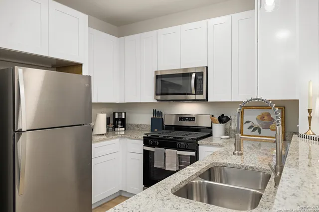 a kitchen with a refrigerator a microwave a sink and cabinets