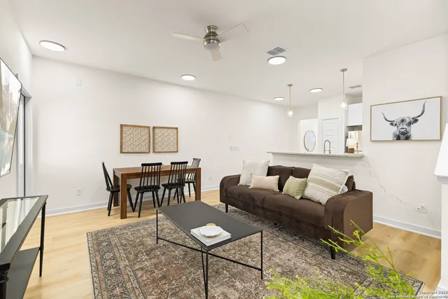 a living room with furniture and a dining table with kitchen view