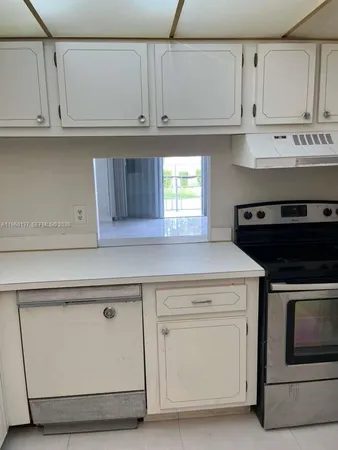a kitchen with granite countertop white cabinets and a stove