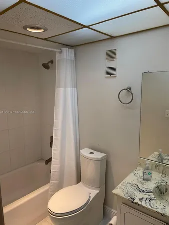 a white toilet sitting next to a bath tub