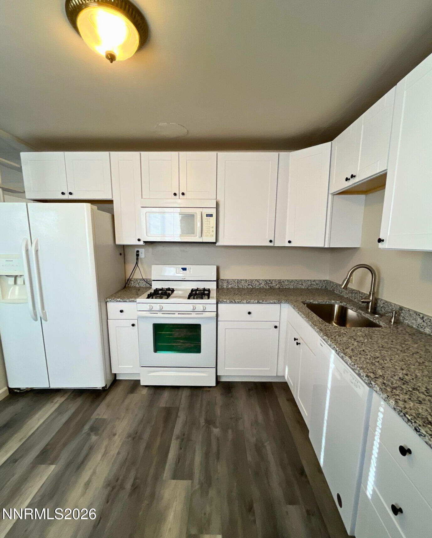 2390 Nelson Way Sparks, NV 89431 - Photo 6 of 16 a kitchen with granite countertop white cabinets and white appliances