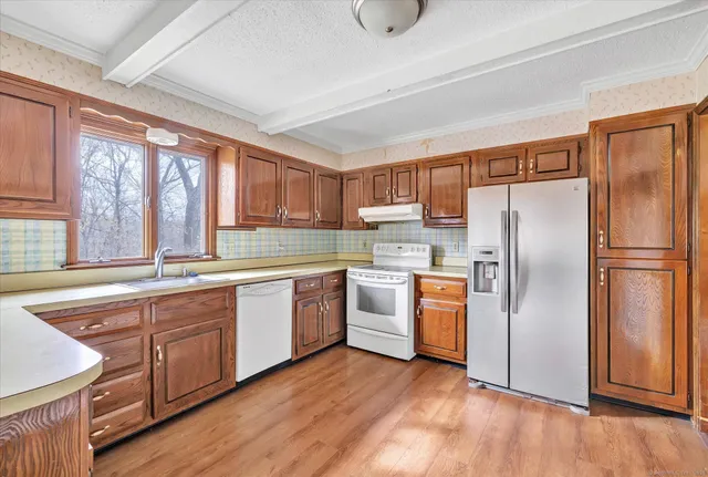 a kitchen with granite countertop a stove a sink dishwasher and a refrigerator