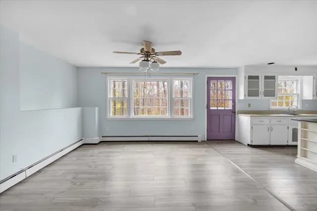 a dining room with wooden floor and chandelier