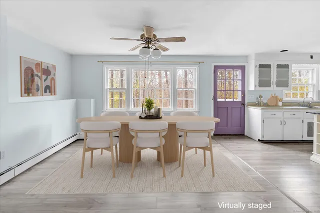 a open kitchen with stainless steel appliances granite countertop a stove top oven a refrigerator a dining table and chairs with wooden floor