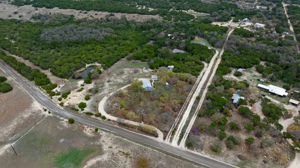 an aerial view of a residential houses with yard